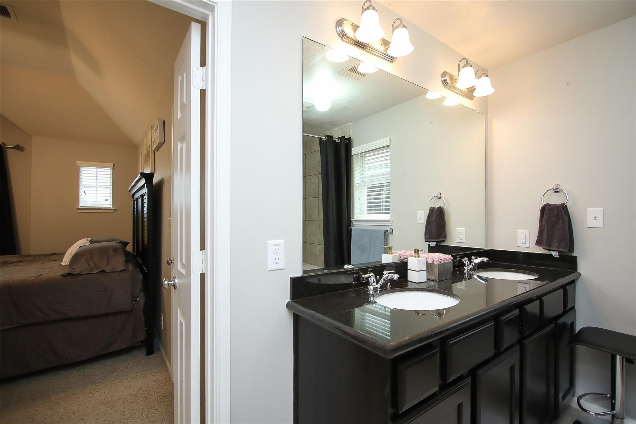 8517 Sunset Loch Drive Spring, TX 77379 - Photo 16 of 22 a bathroom with a granite countertop sink a large mirror and a vanity