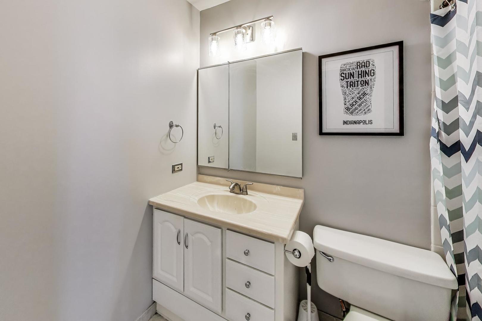 1122 North Clark Street, Unit 3304 Chicago, IL 60610 - Photo 13 of 32 a bathroom with a granite countertop sink a toilet and a mirror