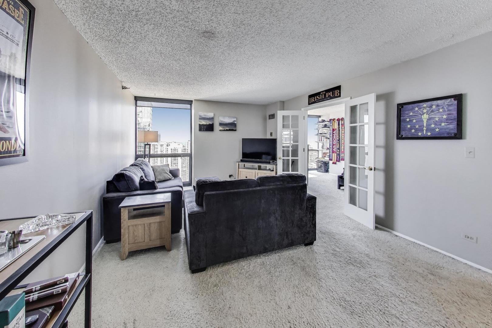 1122 North Clark Street, Unit 3304 Chicago, IL 60610 - Photo 2 of 32 a living room with furniture and a flat screen tv