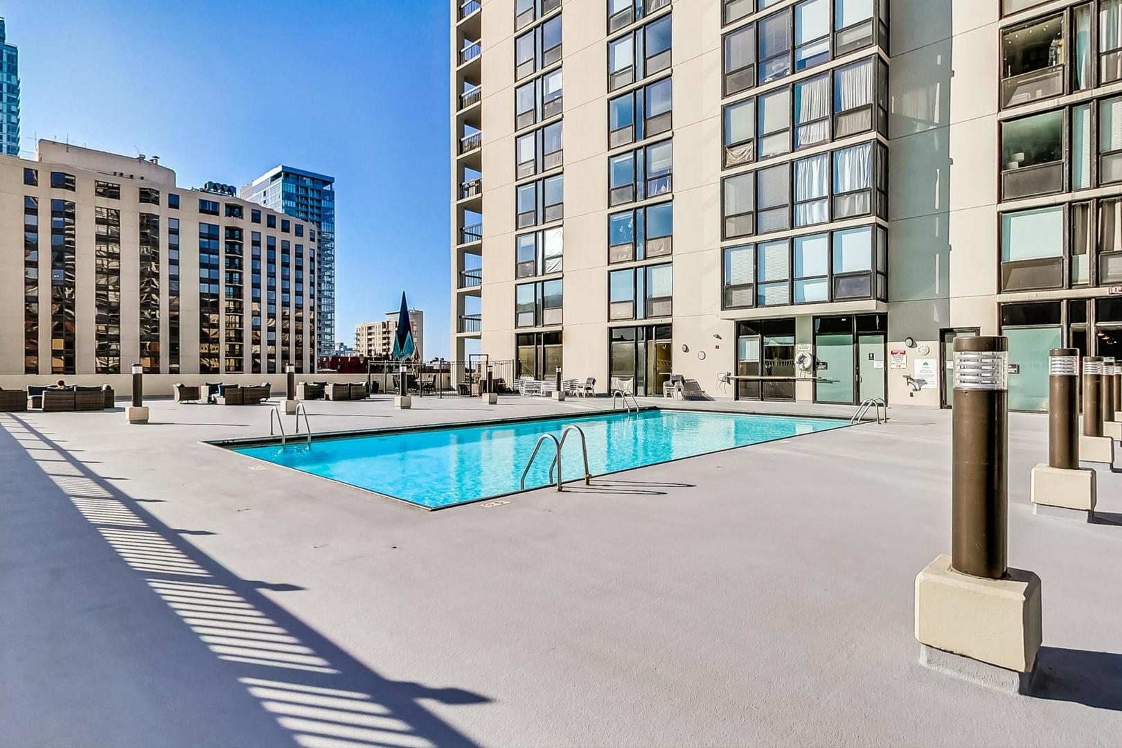 1122 North Clark Street, Unit 3304 Chicago, IL 60610 - Photo 27 of 32 a swimming pool with buildings in the background