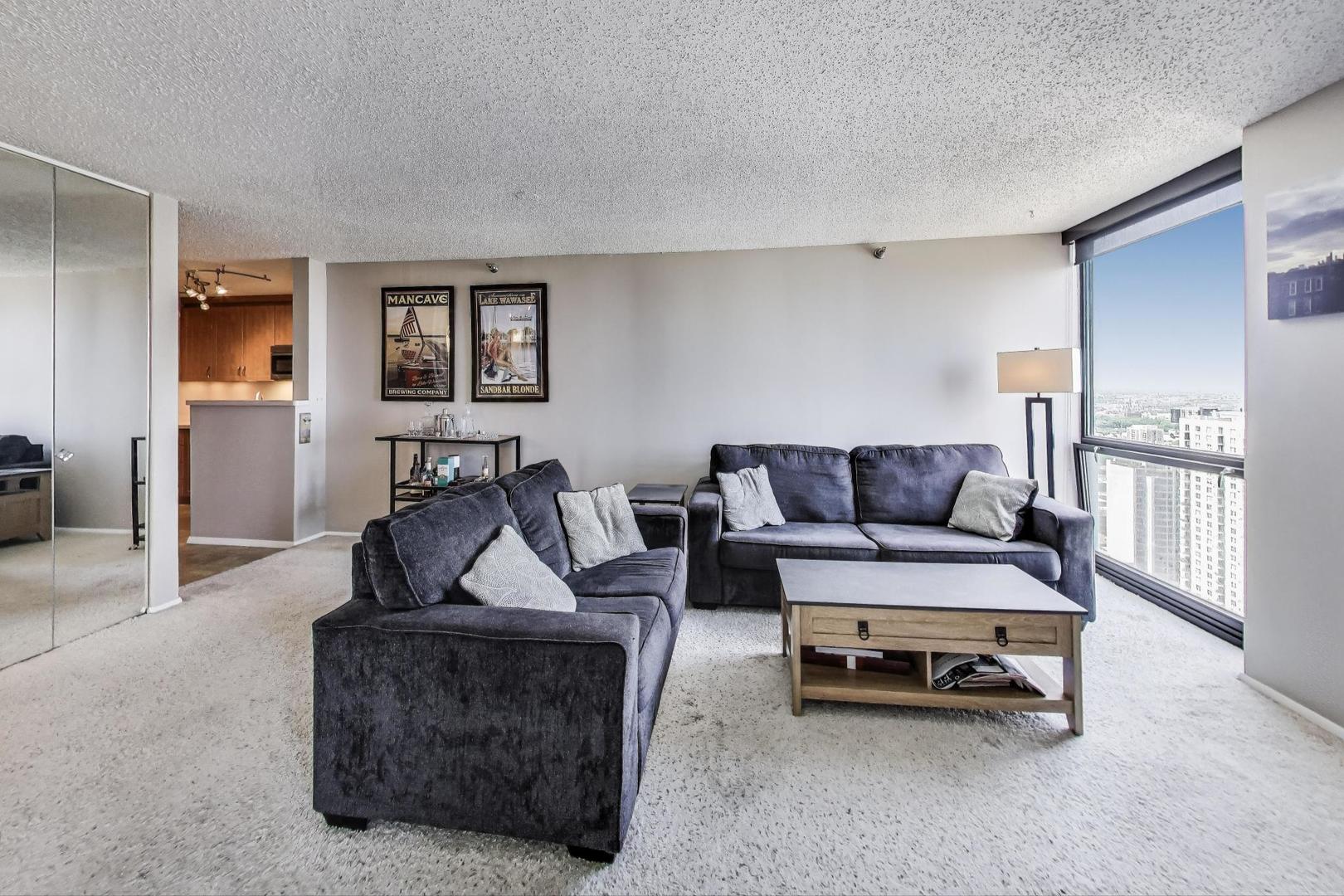 1122 North Clark Street, Unit 3304 Chicago, IL 60610 - Photo 3 of 32 a living room with furniture and a wooden floor