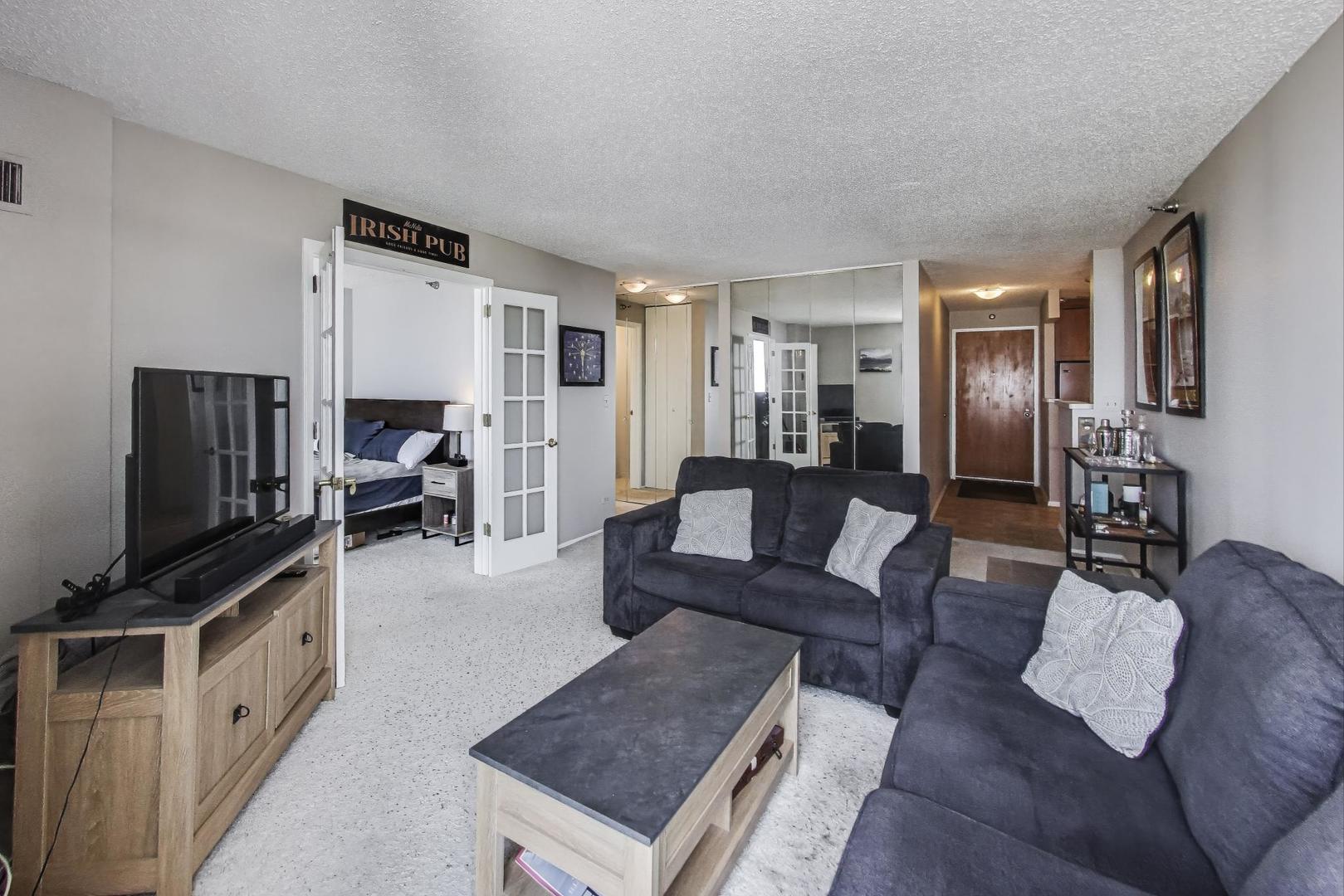 1122 North Clark Street, Unit 3304 Chicago, IL 60610 - Photo 4 of 32 a living room with furniture and a flat screen tv