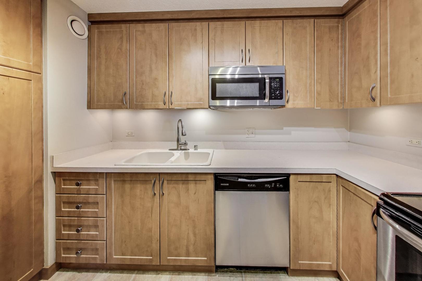 1122 North Clark Street, Unit 3304 Chicago, IL 60610 - Photo 7 of 32 a kitchen with a sink and a microwave
