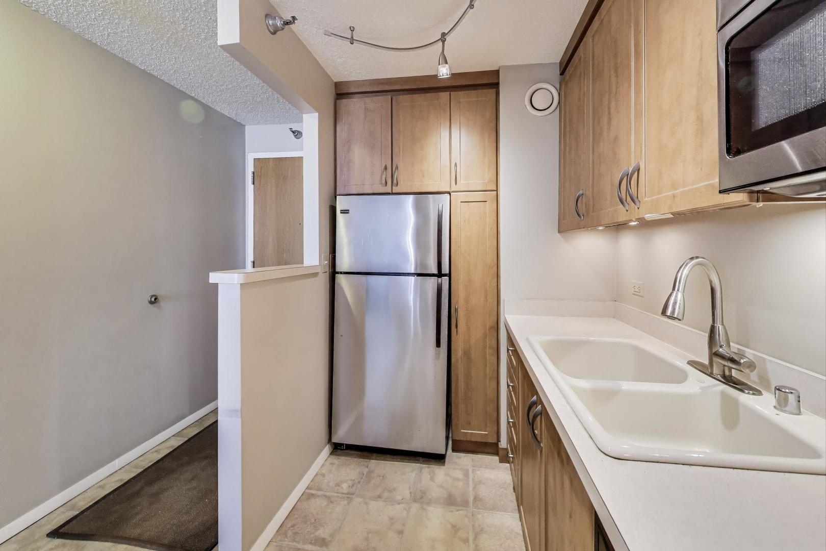 1122 North Clark Street, Unit 3304 Chicago, IL 60610 - Photo 8 of 32 a kitchen with stainless steel appliances a refrigerator and a sink