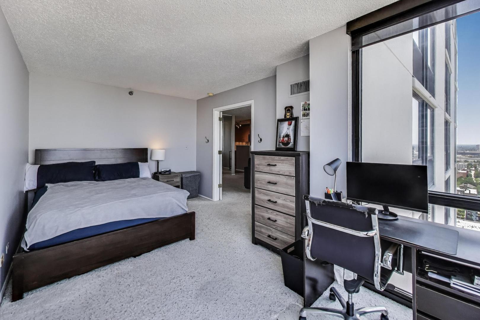 1122 North Clark Street, Unit 3304 Chicago, IL 60610 - Photo 9 of 32 a bedroom with a bed and a flat screen tv