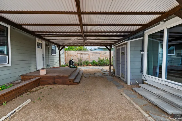 a view of a backyard with wooden floor and iron stairs