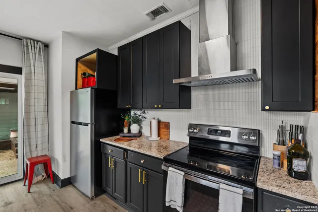 a kitchen with stainless steel appliances granite countertop a refrigerator and a stove top oven
