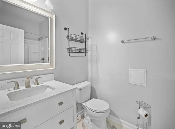 a bathroom with a granite countertop sink mirror vanity and toilet