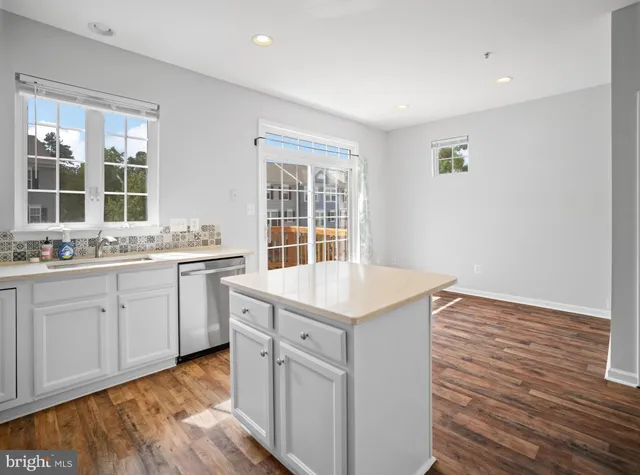 a kitchen with a sink cabinets appliances and a window