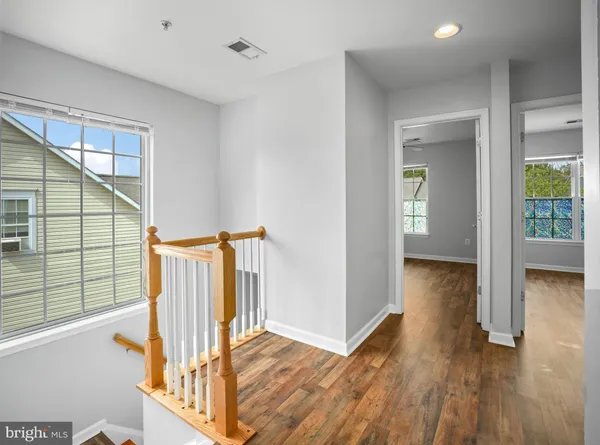 a view of a hallway with wooden floor and stairs