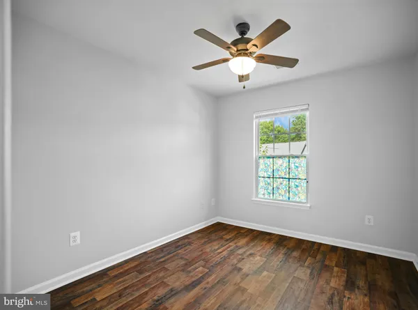 an empty room with window and ceiling fan