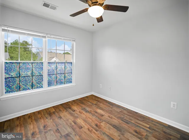 wooden floor in an empty room with a window