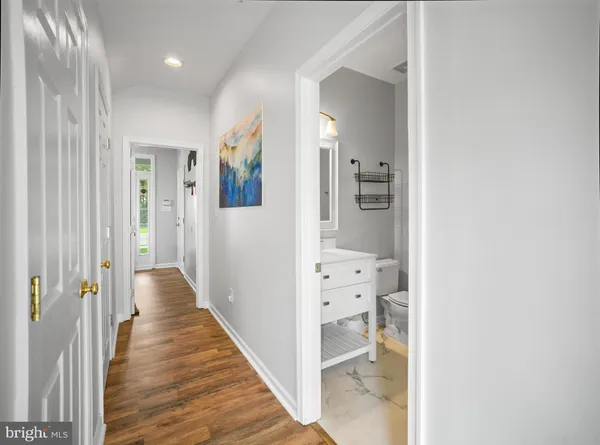 a view of a hallway with wooden floor and staircase