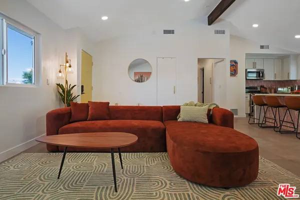 a living room with furniture kitchen view and a table