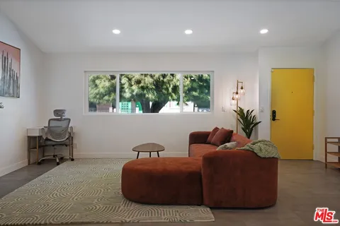 a living room with furniture and a potted plant