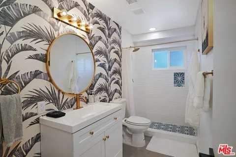 a bathroom with a sink mirror vanity and toilet