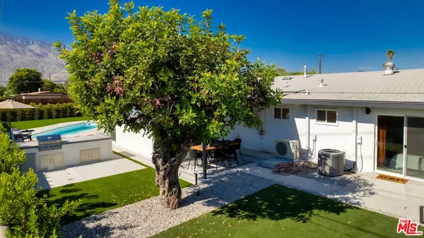 a view of a house with backyard sitting area and garden