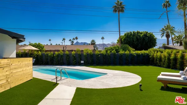 a swimming pool with outdoor seating and yard