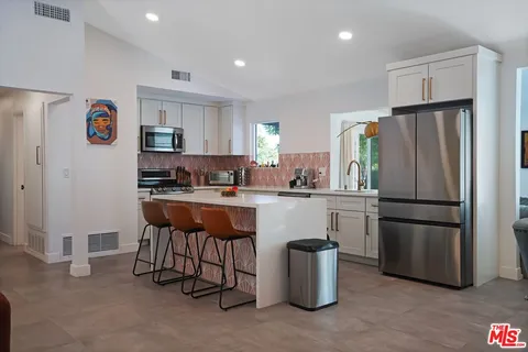 a kitchen with refrigerator and table
