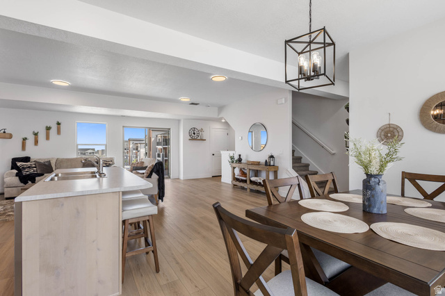 636 West Caroles Way, Unit 7 Tooele, UT 84074 - Photo 10 of 31 Open-concept living space featuring wood-finish flooring, recessed lighting, and a contemporary dining chandelier