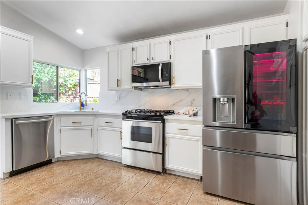 16366 West Sun Canyon Street Riverside, CA 92503 - Photo 7 of 21 a kitchen with stainless steel appliances white cabinets and a window