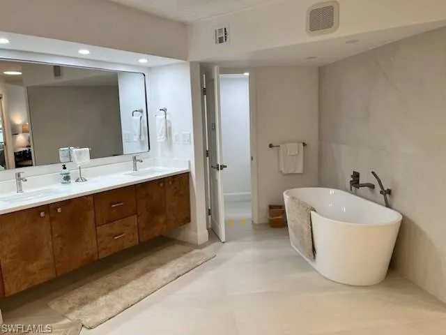 a spacious bathroom with a double vanity sink mirror and bathtub