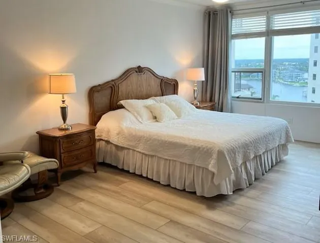 a bedroom with a bed and a large window