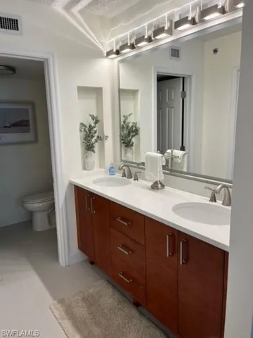 a bathroom with a double vanity sink and a toilet