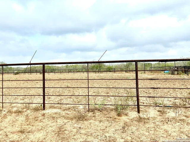 a view of a yard with wooden fence