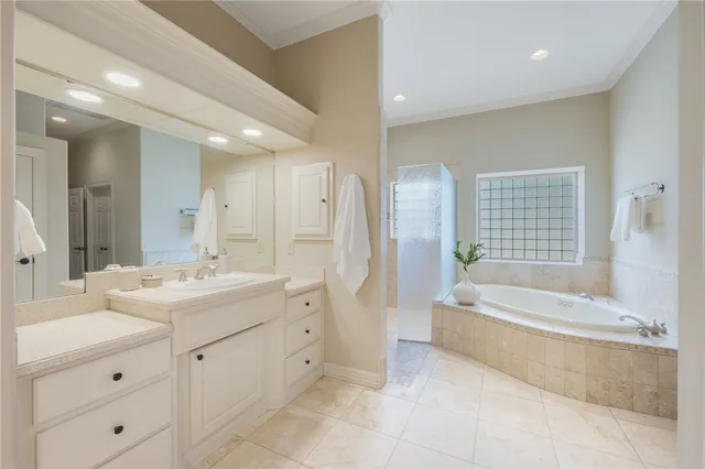 a spacious bathroom with a double vanity sink a mirror and a bathtub