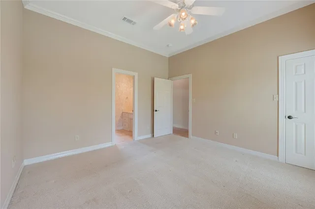 a view of an empty room with a chandelier fan