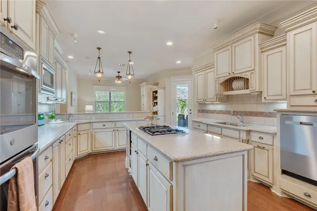 a kitchen with stainless steel appliances granite countertop a sink stove and cabinets