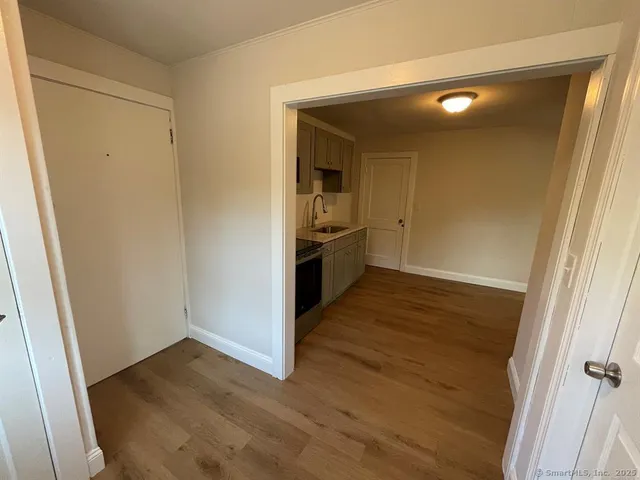 an empty room with wooden floor and entrance