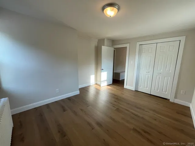 an empty room with wooden floor and closet