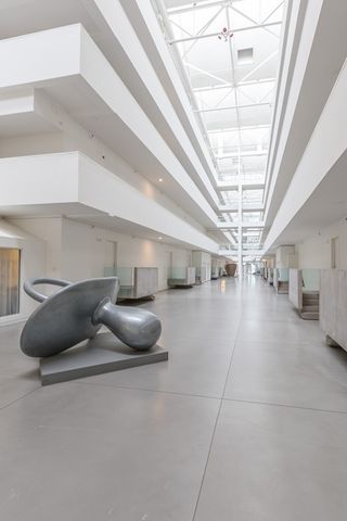 a room with lots of white furniture and a chandelier
