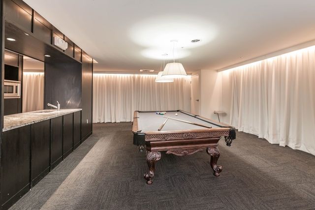 a room with pool tables and chandelier