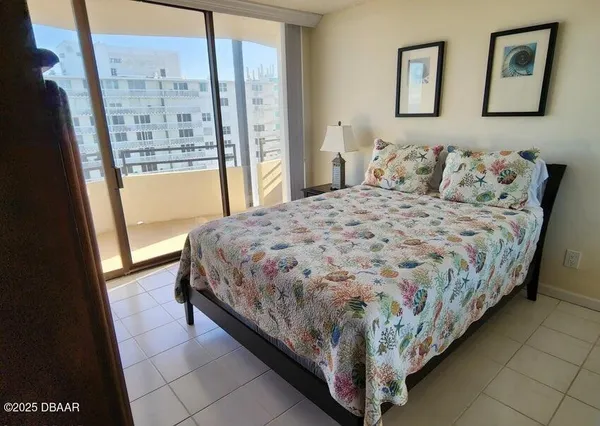 a bedroom with a bed dresser and a large window