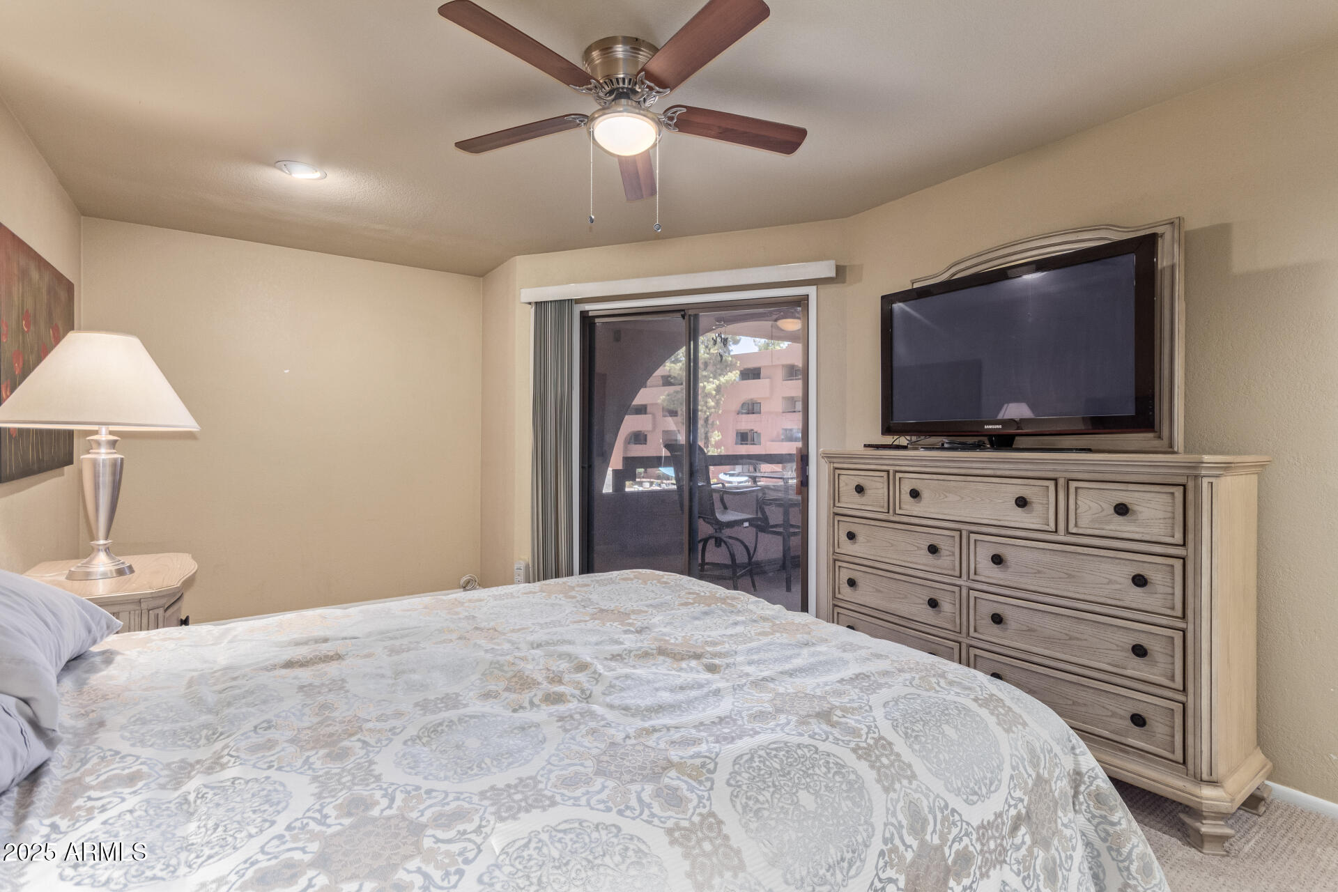 4303 East Cactus Road, Unit 202 Phoenix, AZ 85032 - Photo 11 of 34 a bedroom with a bed a chandelier and a flat screen tv
