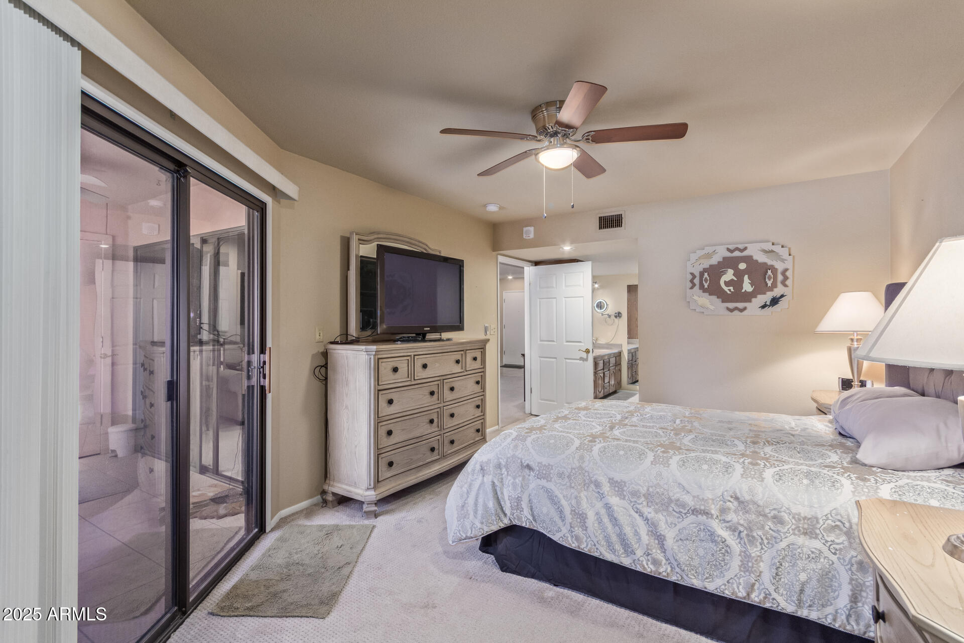 4303 East Cactus Road, Unit 202 Phoenix, AZ 85032 - Photo 12 of 34 a bedroom with a large bed and a flat tv screen on dresser