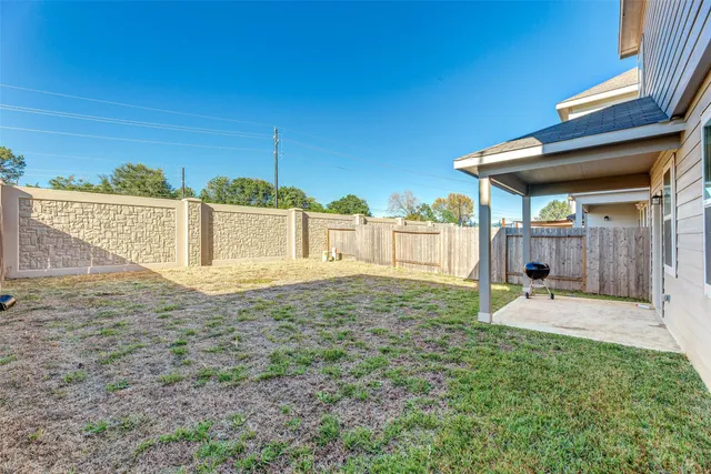 a white house with a small yard and wooden fence