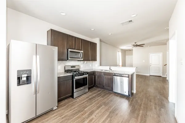 a kitchen with stainless steel appliances granite countertop a refrigerator stove and sink