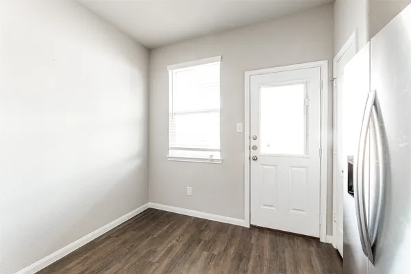 an empty room with wooden floor and a window