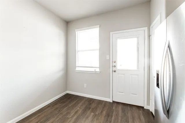 an empty room with wooden floor and a window