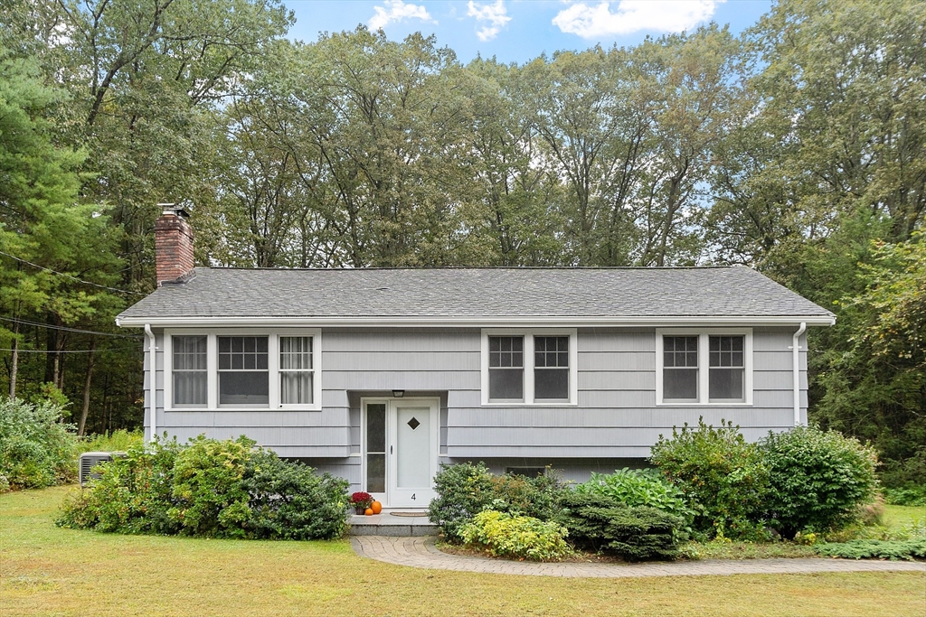 a front view of a house with a yard and potted plants