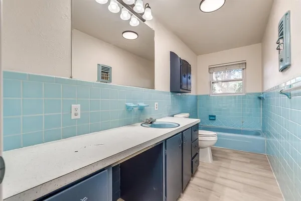 a bathroom with a sink a toilet and a mirror