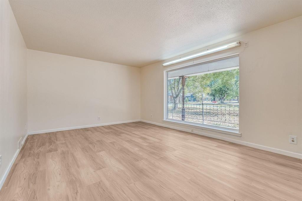 921 Evans Street Bonham, TX 75418 - Photo 18 of 28 a view of an empty room with wooden floor and a window