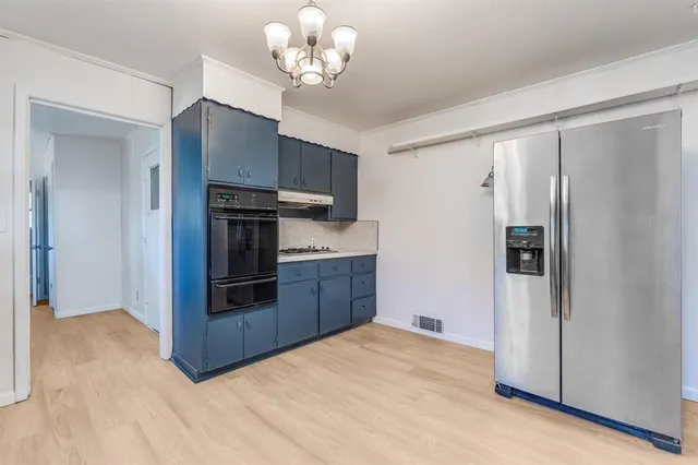 a kitchen with stainless steel appliances granite countertop a refrigerator and a stove top oven
