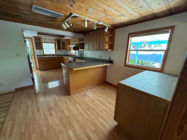 a large kitchen with wooden floors and stainless steel appliances