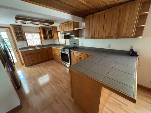 a kitchen with stainless steel appliances kitchen island granite countertop a sink stove and cabinets