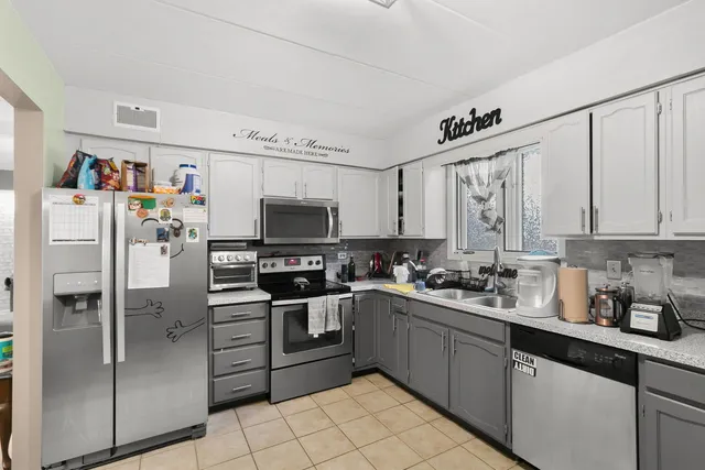 a kitchen with a refrigerator a sink cabinets and microwave